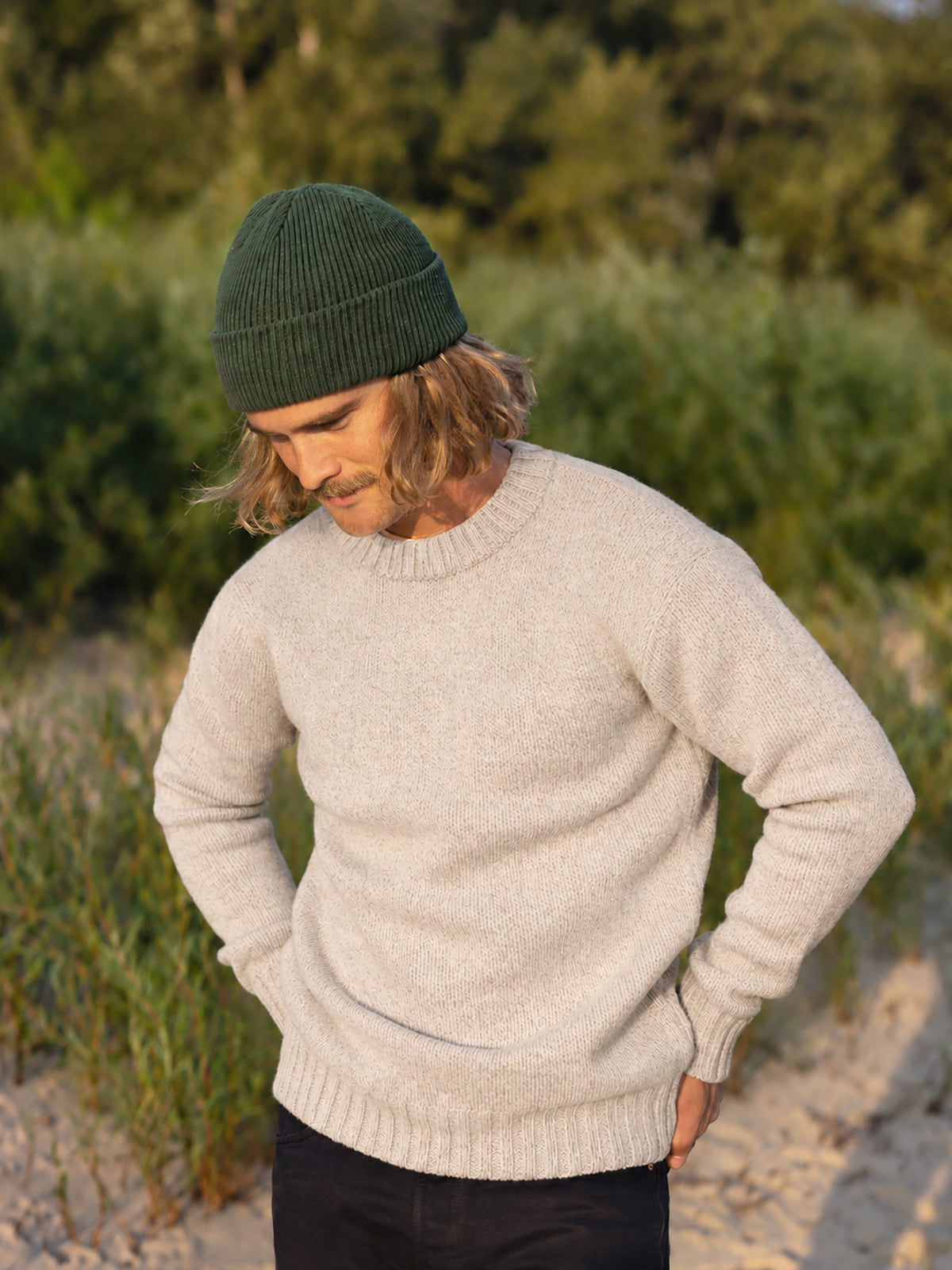 Kelsey trägt unseren Männer Merino Strickpullover in beigemeliert aus 100% Merinowolle und fair in Deutschland hergestellt
