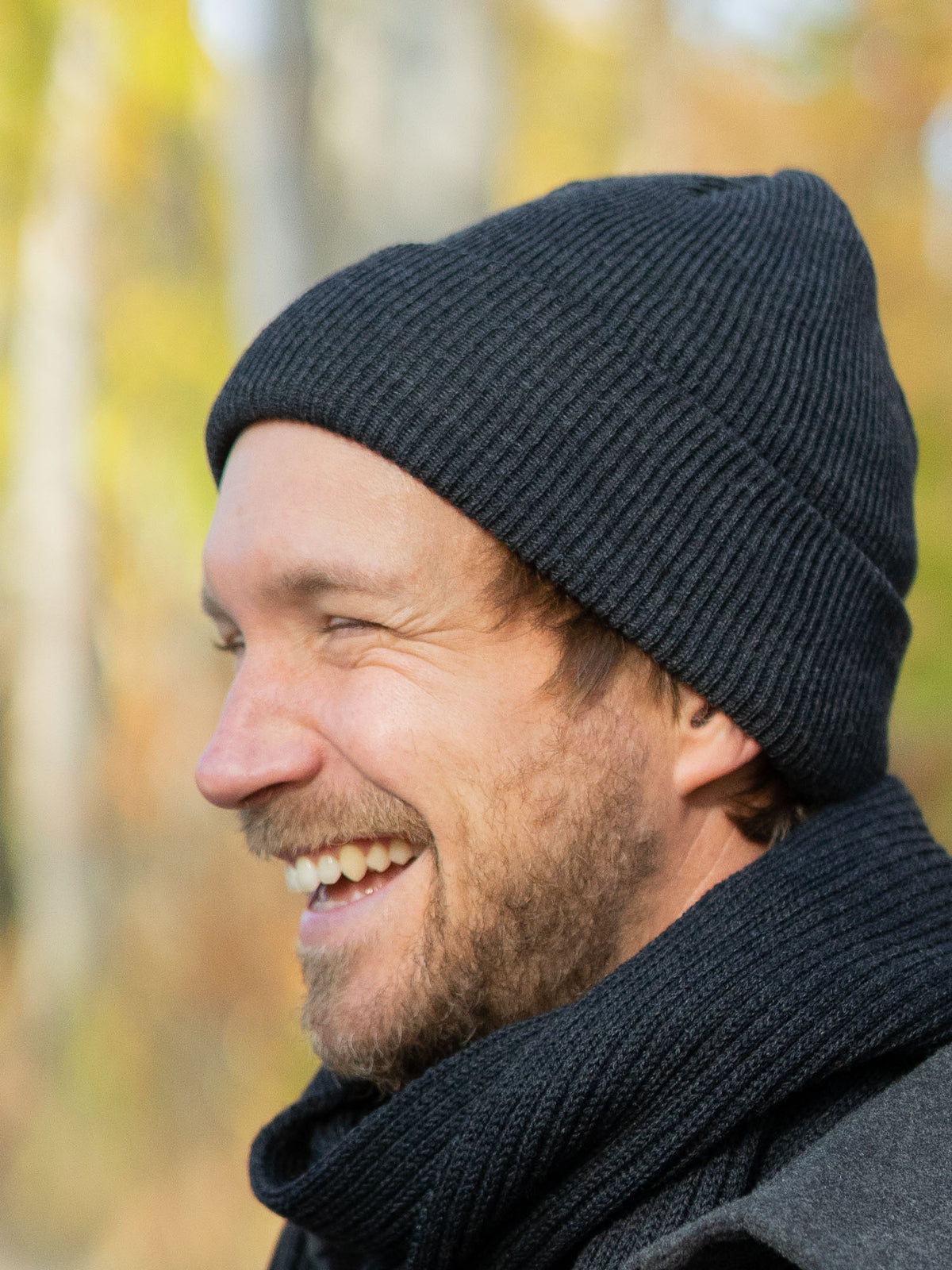 Junger, blonder Mann trägt eine fair gefertigte Strickmütze von FUXBAU aus 100% Merino Schurwolle. GOTS zertifiziert und gestrickt in Deutschland.