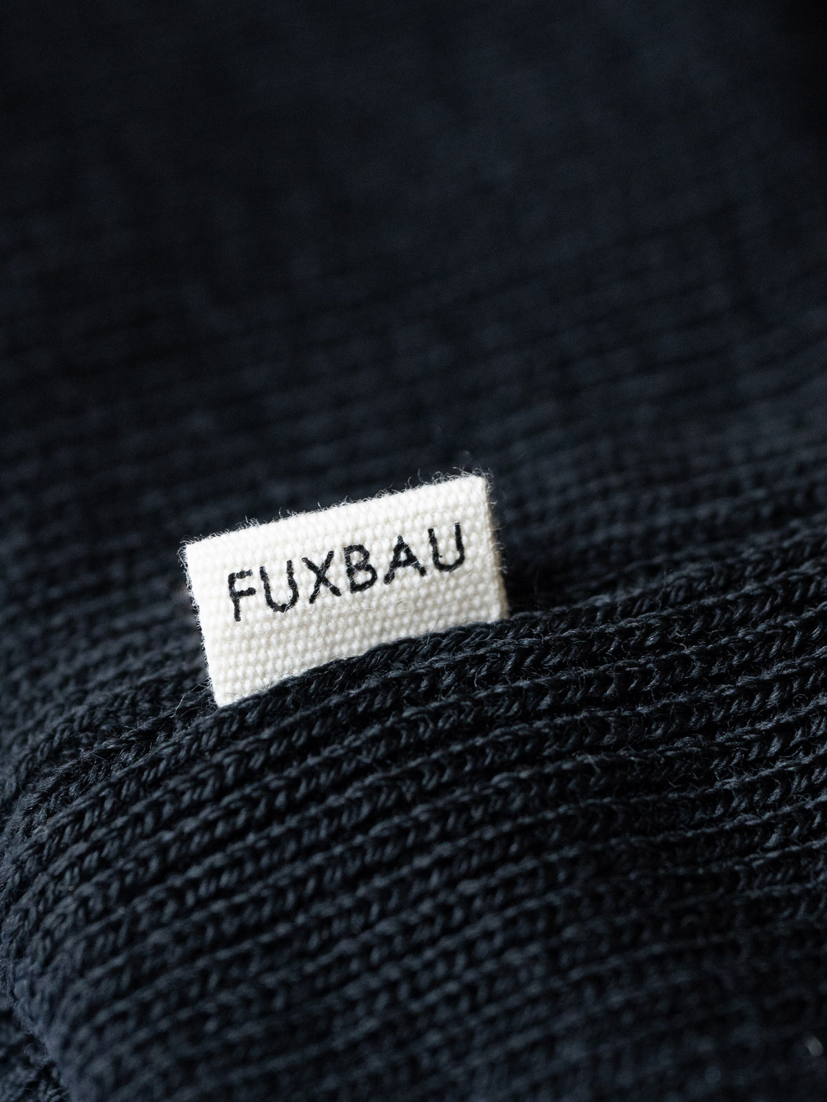 Kenny trägt unsere Merino Strickmütze aus 100% GOTS zertifizierter Schurwolle in schwarz.
