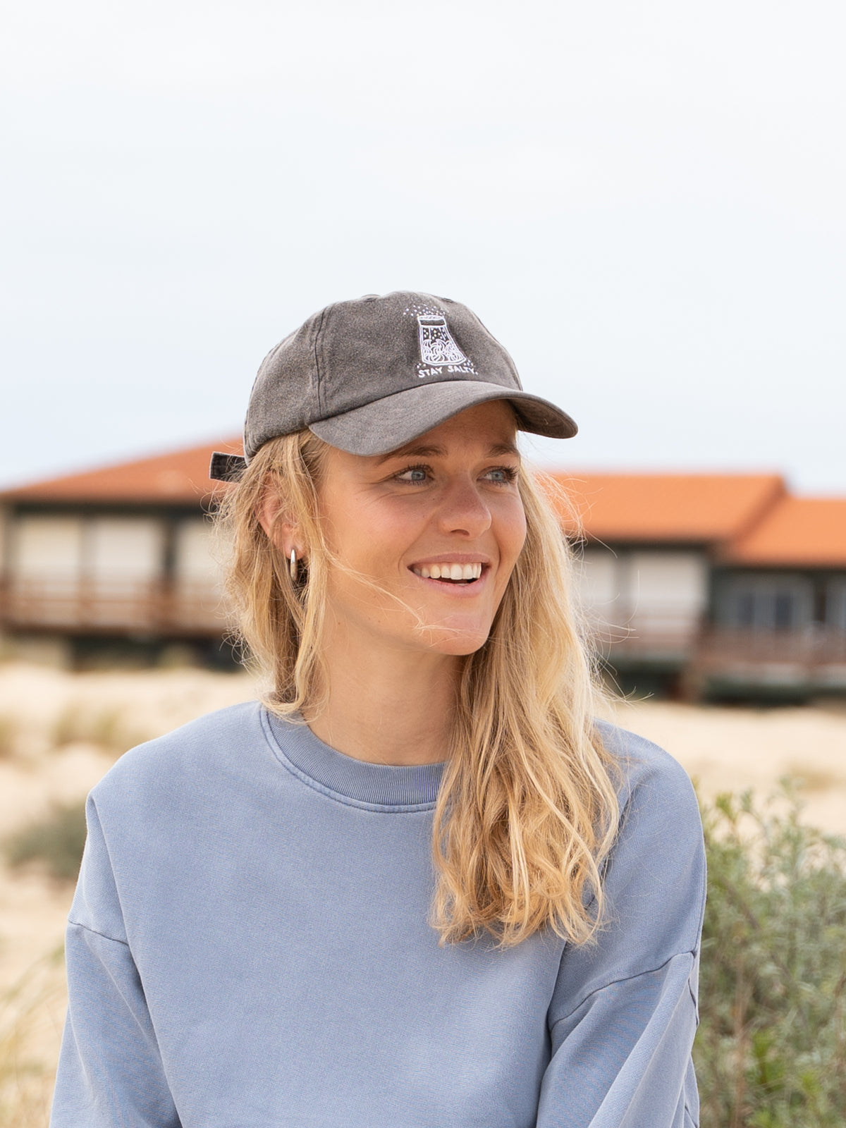 Greta trägt unsere faire Stay Salty Dad Cap in salzschwarz aus 100% GOTS zertifizierter Biobaumwolle Made in Portugal.