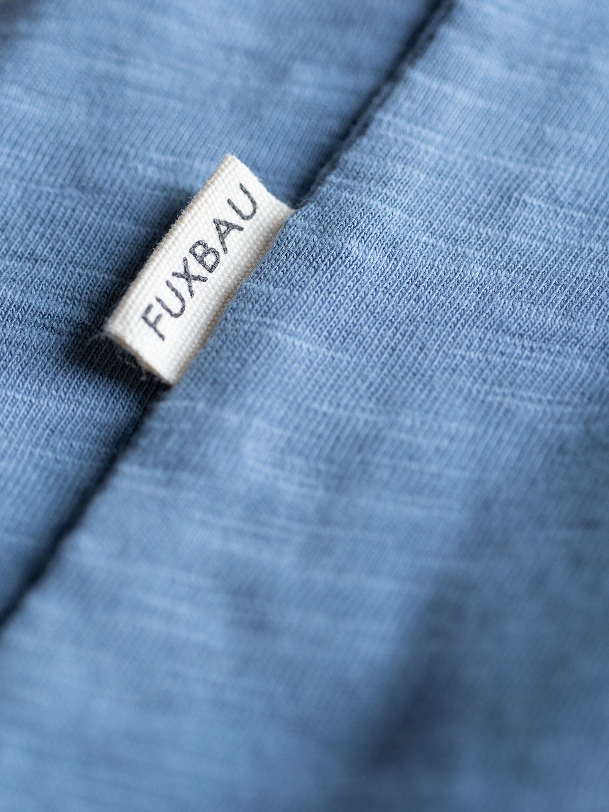 Detailansicht einer Sideflag in weiß vom Fair Fashion Männer Azul T-Shirt von FUXBAU aus 100% GOTS Bio-Baumwolle.
