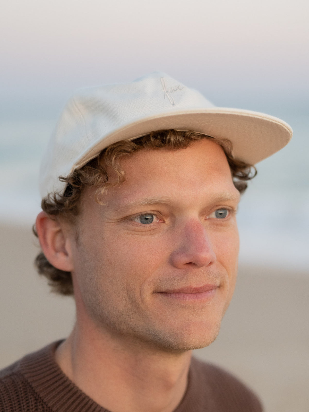 Unisex Fair Fashion FUXBAU Cap in cremeweiss mit ton-in-ton fux Stick aus Biobaumwolle. Gefertigt in Manufaktur-Qualität in Polen und getragen am Strand in Portugal.