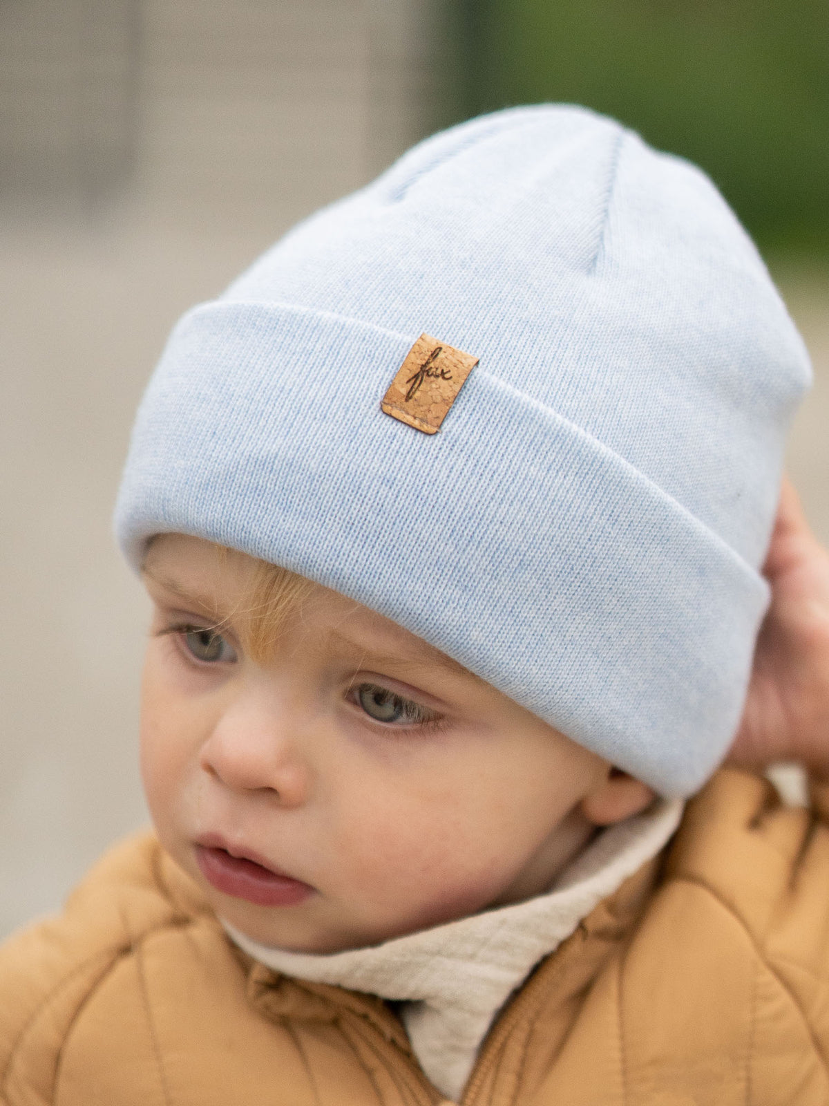 Detailaufnahme eisblaue Kinder Merino Kork Beanie von FUXBAU – Kindermütze aus Merinowolle, Made in Germany.