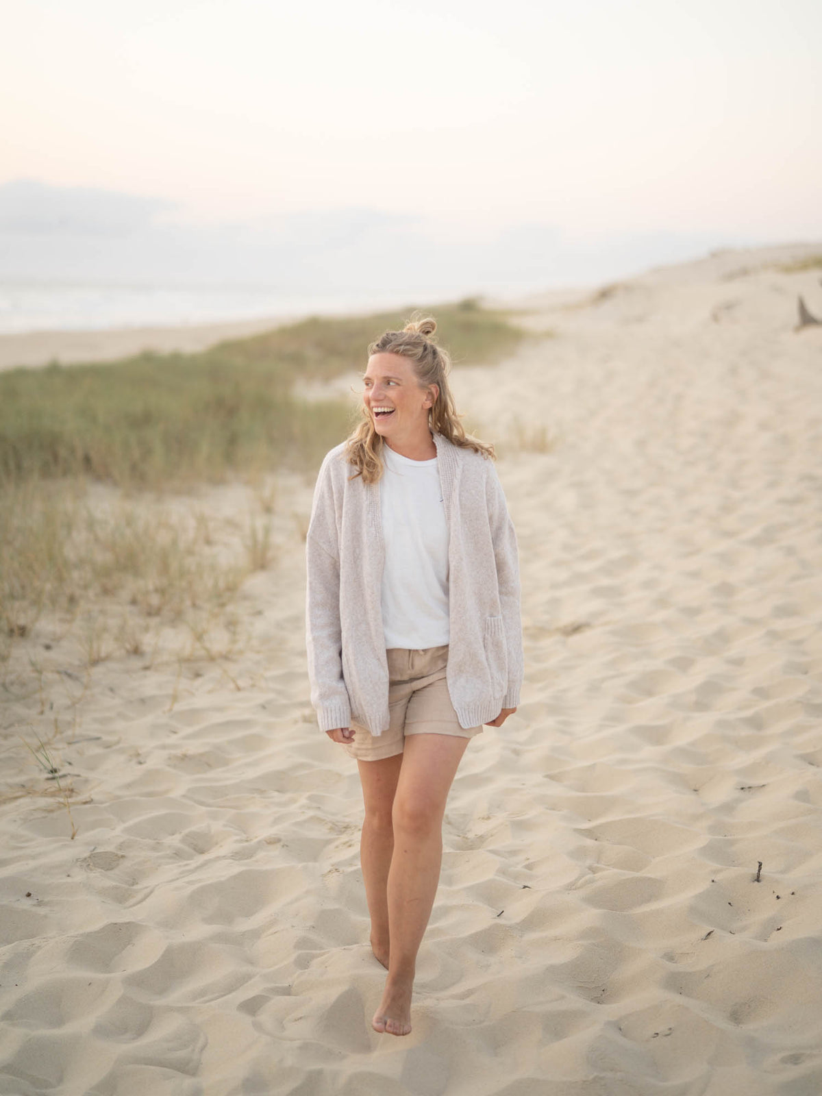 Isi trägt unseren FUXBAU Oversize Merino Cardigan in beigemeliert aus 100% Merinowolle für Frauen
